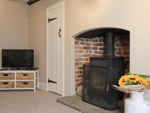 a living room with a fireplace and a tv at Anchor Cottage in Deal