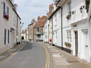 an empty street in a town with white houses at Anchor Cottage in Deal