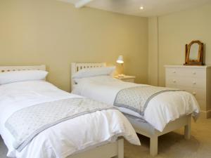 two white beds in a bedroom with a mirror at Anchor Cottage in Deal