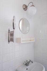 La salle de bains blanche est pourvue d'un lavabo et d'un miroir. dans l'établissement Kvarnstugan, à Mollösund