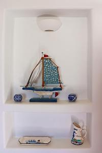 a shelf with a model of a boat on it at Antheia Suite of Mykonos in Ano Mera