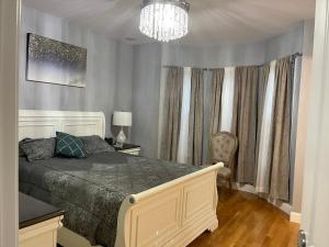 a bedroom with a large bed and a chandelier at Brand New Luxury Rooms near downtown Boston in Boston