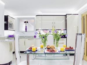 a kitchen with a glass table with food and flowers at Riviera Mews in Torquay