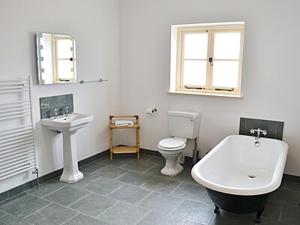 a bathroom with a sink and a tub and a toilet at Manor Farm Retreat in Hainford