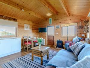 a living room with a couch and a table at Buttercup Lodge in Broomhill