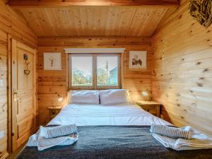 ein Schlafzimmer mit einem Bett in einer Holzhütte in der Unterkunft Buttercup Lodge in Broomhill