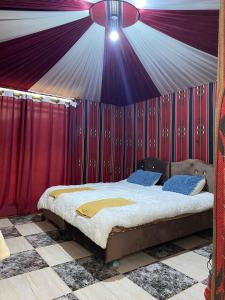 um quarto com uma cama numa tenda em Blue Camel em Wadi Rum