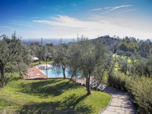 uitzicht op een zwembad met bomen in de tuin bij Belvilla by OYO Landman Apartment in Larciano