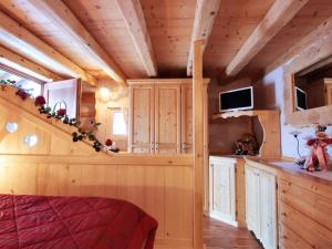 a cabin kitchen with wooden walls and wooden ceilings at Attractive chalet in Transacqua with garden in Transacqua