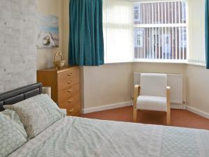 sypialnia z łóżkiem, krzesłem i oknami w obiekcie Seashells w mieście Woodhorn