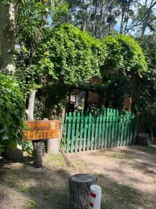 una señal frente a una valla verde en Cabañas mateo en Balneario Mar Azul