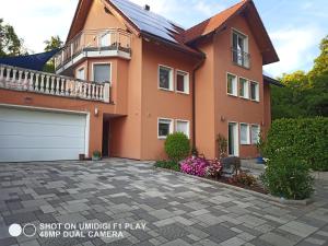 a large orange house with a driveway at Ferienwohnung DaWie in Öhringen