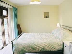 Schlafzimmer mit einem Bett und einem Fenster in der Unterkunft The Threshing Barn in Westbury-sub-Mendip
