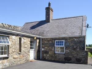 an old stone house with a white door at Bodwi Bach in Llanengan