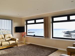 a living room with a couch and two large windows at The Waves in Wick