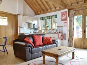 a living room with a leather couch and a coffee table at The Waggon House in Arlingham