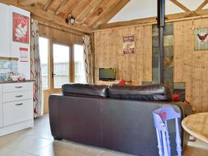 a living room with a leather couch and a table at The Waggon House in Arlingham