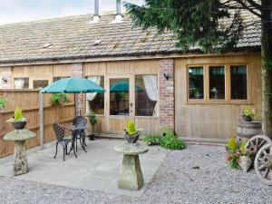 a patio with a table and an umbrella at The Waggon House in Arlingham