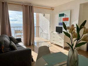- un salon avec un canapé et une vue sur l'océan dans l'établissement Apartamento frente al mar en Calpe con parking para 4 personas, à Calp