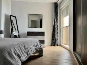 - une chambre avec un lit, un miroir et une fenêtre dans l'établissement Apartamento frente al mar en Calpe con parking para 4 personas, à Calp