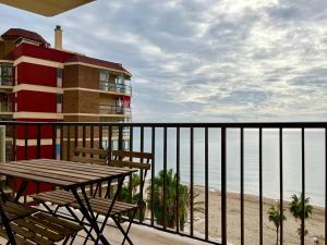 einen Balkon mit Tisch und Stühlen sowie Strand in der Unterkunft Apartamento frente al mar en Calpe con parking para 4 personas in Calpe