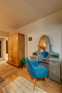 a living room with a blue chair and a mirror at Cool Opera Apartments in Cluj-Napoca