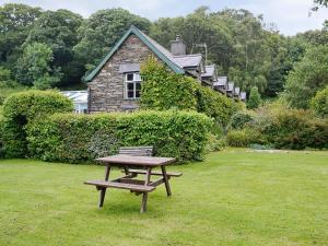 a picnic table and a bench in front of a house at Erw Goed Hen Stabl in Arthog