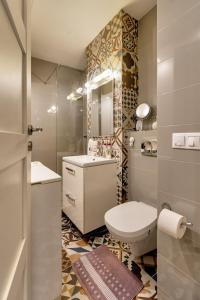 a bathroom with a toilet and a sink and a mirror at Cool Opera Apartments in Cluj-Napoca