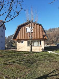 ein kleines Haus mit einem Baum davor in der Unterkunft LAF Guest House in Kolašin