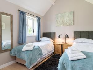 a bedroom with two beds and a mirror at Canal View in Ellesmere