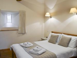 1 dormitorio con 1 cama con toallas en The Old Dairy - 26726, en North Willingham