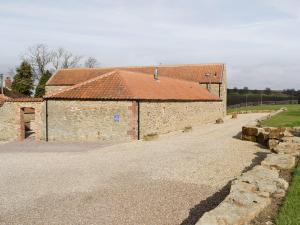 un gran edificio de ladrillo con techo rojo en The Old Dairy - 26726, en North Willingham