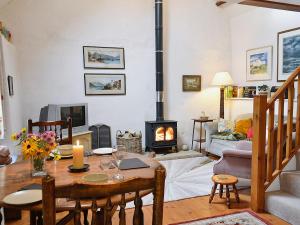 a living room with a table and a fireplace at Pant Y Bryn Bach in Cilycwm