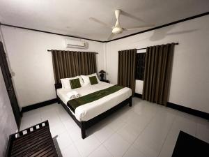 um quarto com uma cama e uma ventoinha de tecto em Lao Lake House em Vientiane