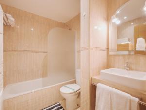 a bathroom with a toilet and a tub and a sink at Apartamento "MACHOTE" in Tordesillas