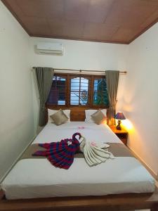 a bedroom with a bed with a parrot on it at Kusnadi Hotel in Legian