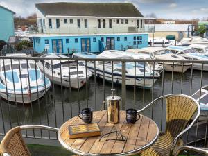 a table and chairs with boats in a marina at Heron in Wroxham