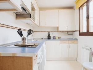 a kitchen with white cabinets and a bowl of utensils at Apartamento "RASCALINDES" in Tordesillas
