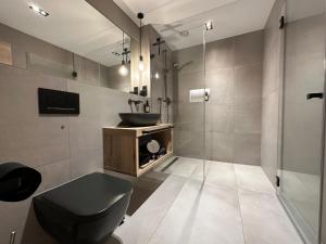 Łazienka z czarną toaletą i umywalką w obiekcie Apartment34 w mieście Öhringen