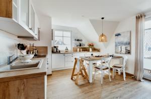 a kitchen with white cabinets and a table and chairs at Ostseeblau in Zingst