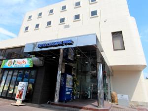 una tienda frente a un edificio con un cartel. en HOTEL LiVEMAX BUDGET Utsunomiya, en Utsunomiya