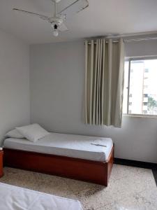1 dormitorio con cama y ventana en Aguas Quentes 601-B, en Caldas Novas