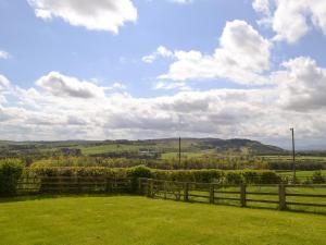 a fence in a field with a view of the hills at Cheviot View in Alnwick