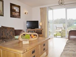 a living room with a table with a basket of fruit on it at Meadow Mews in Stokenham