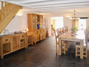 a dining room with a table and wooden cabinets at Meadow Mews in Stokenham