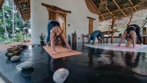 a group of people doing yoga in a room with water at Ella Retreat Cottage for Nature Lovers in Ella