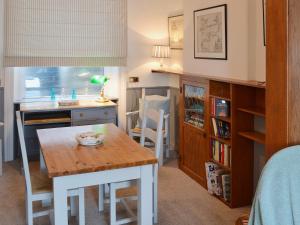 a room with a table and a kitchen with a desk at Waterside in Fowey