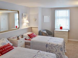a bedroom with two beds and a mirror at Waterside in Fowey