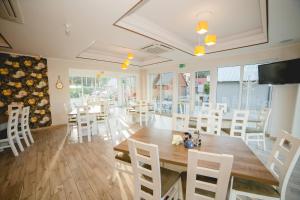 een eetkamer met een houten tafel en stoelen bij Willa Mirella in Dębki