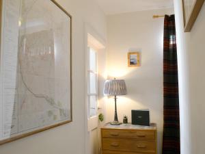 a room with a desk with a lamp and a map on the wall at Langside in Kingussie